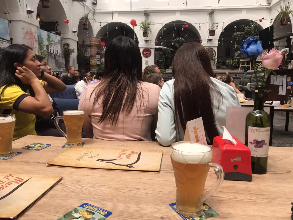 Beers and women watching a football match at a cafe in Quito