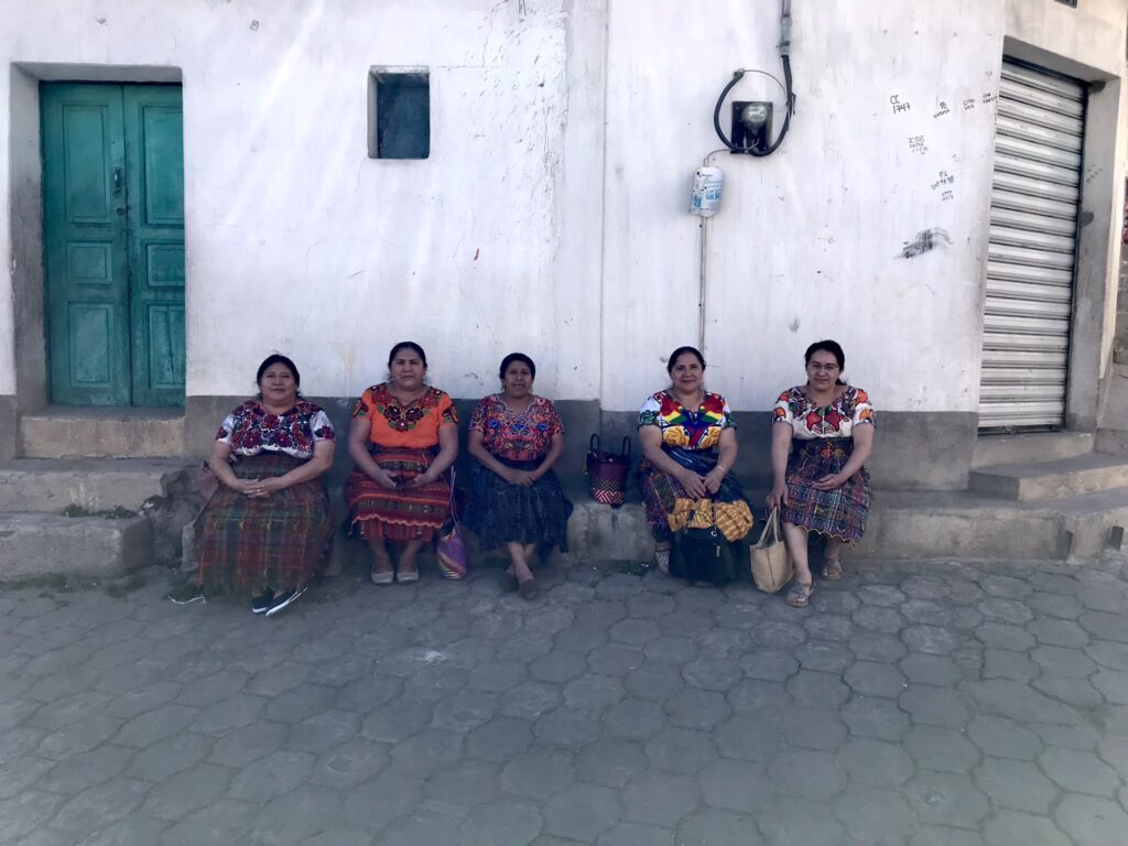 Guatemalan ladies sitting on a pavement