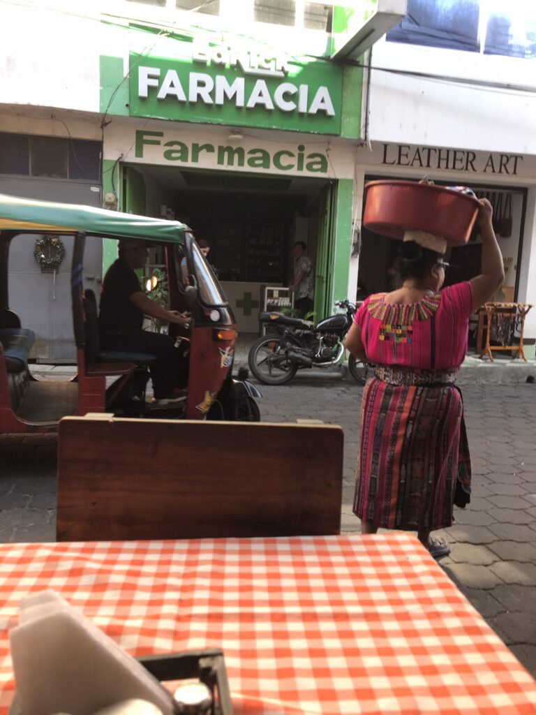 A lady carrying a basket of goods in San Pedro la Laguna