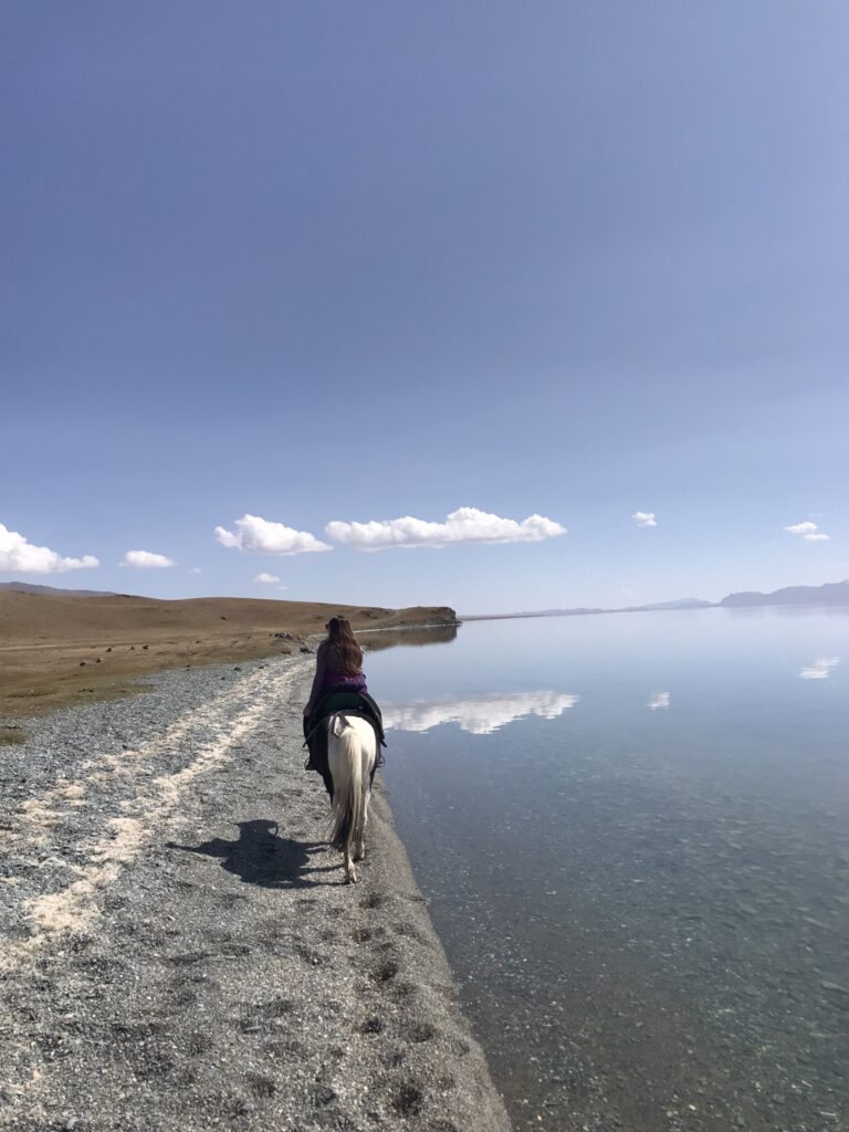 Riding a horse on the shores of Song Kul