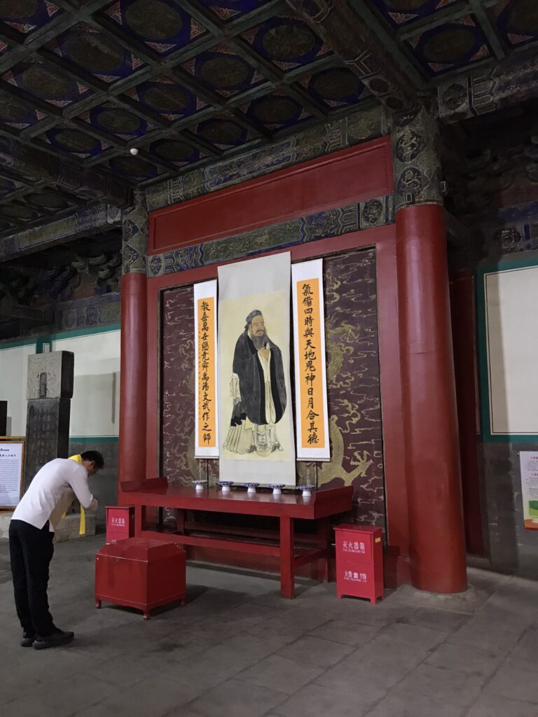 A man bowing to a portrait of Confucius in Qufu